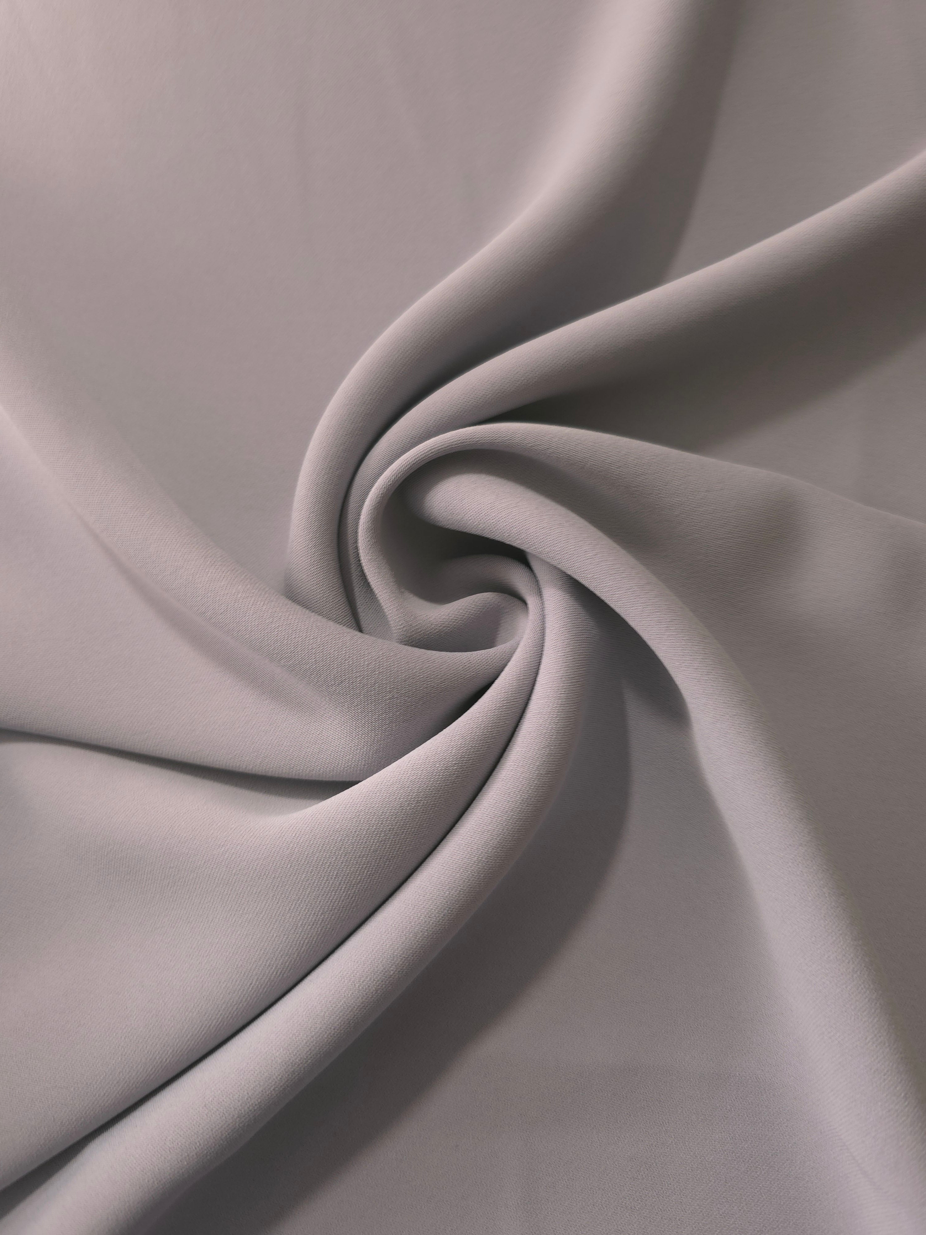 Mushroom Greige polyester crepe arranged in a flowing swirl, showing drape used for abayas and modest fashion