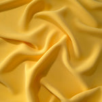 Draped Mustard Yellow Korean polyester crepe showing opaque fluid folds for evening dresses and occasionwear
