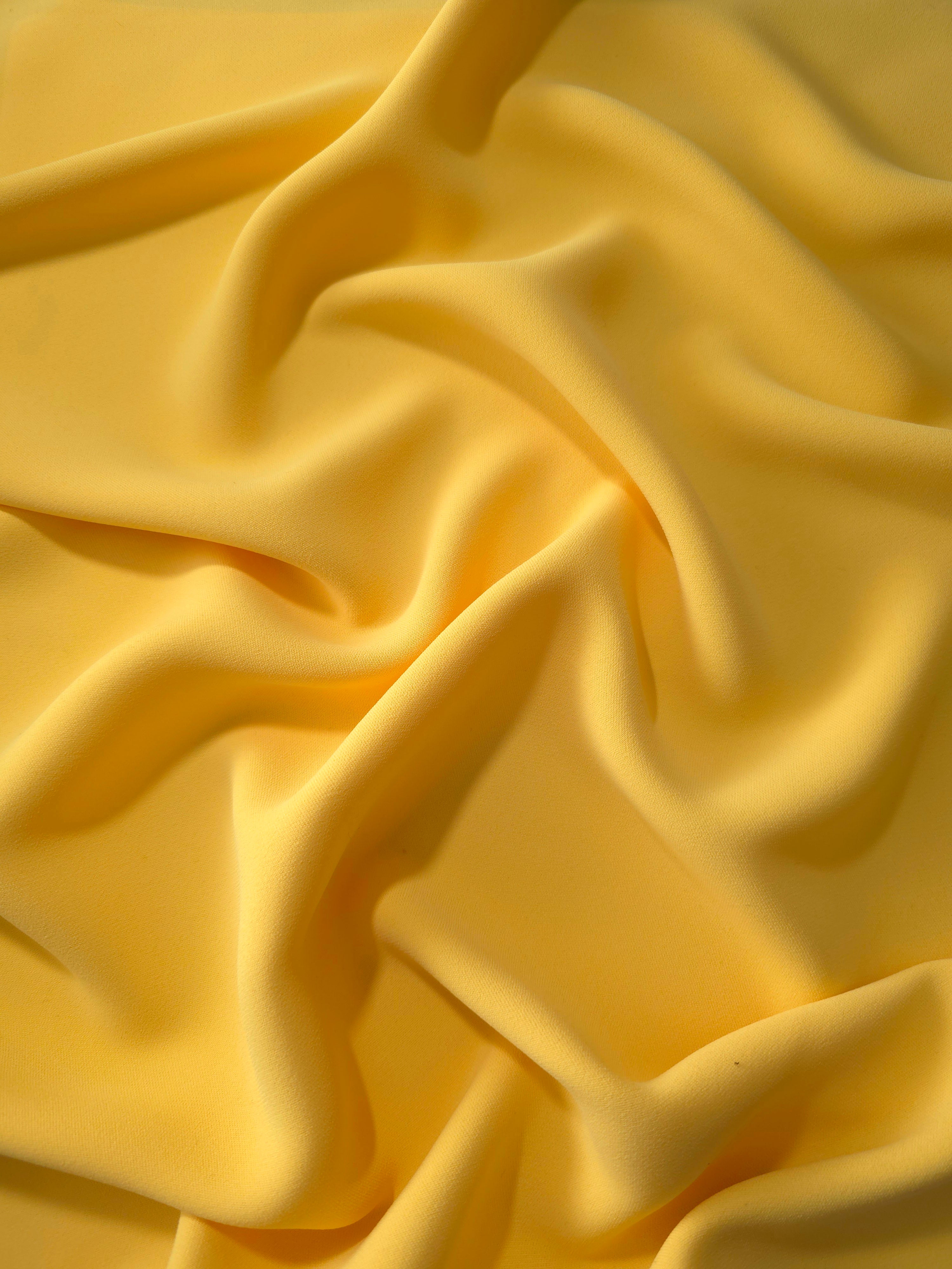Draped Mustard Yellow Korean polyester crepe showing opaque fluid folds for evening dresses and occasionwear
