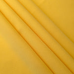 Layered Mustard Yellow mechanical polyester crepe showing soft structure and slight mechanical stretch for tailoring