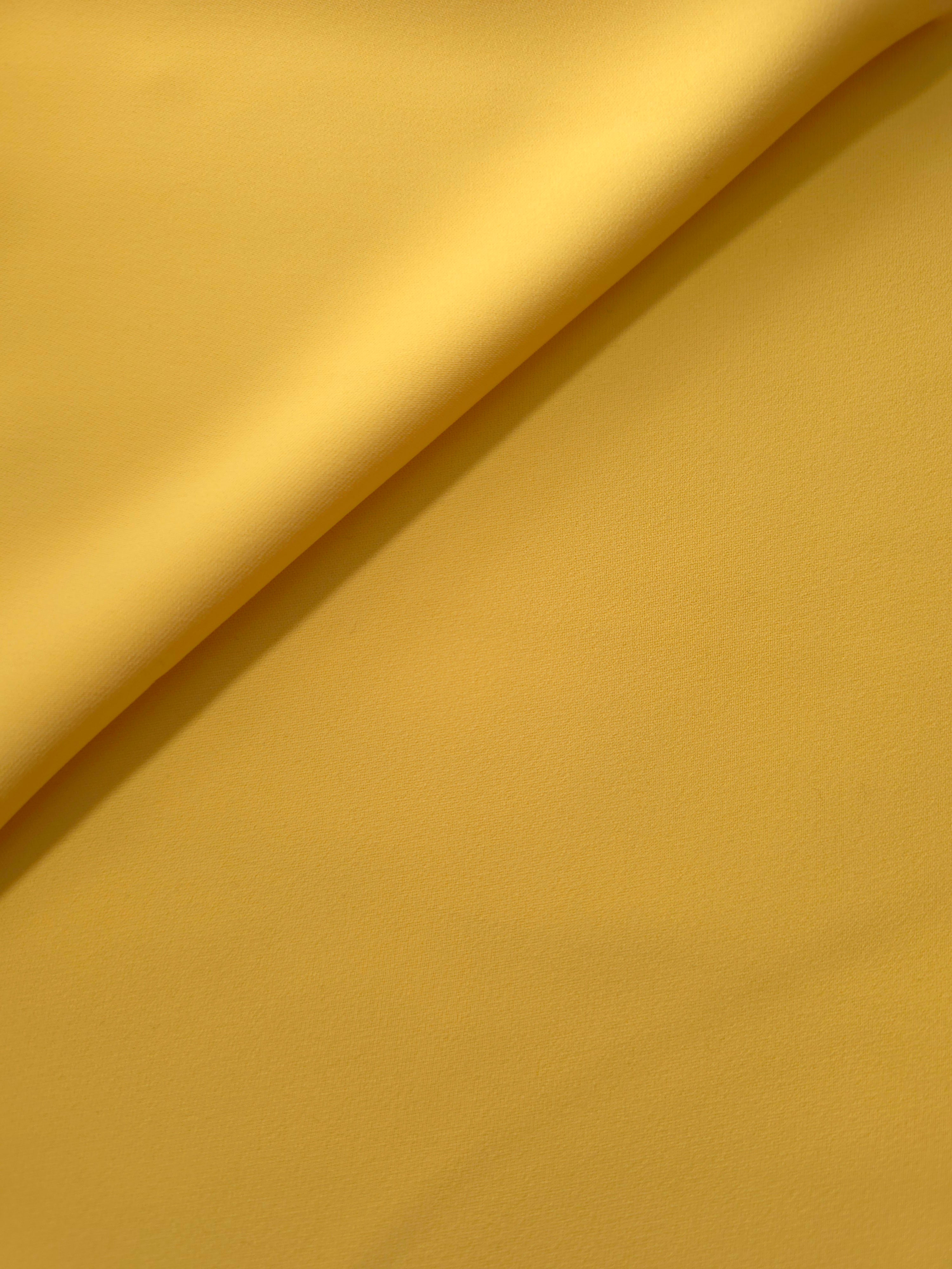 Mustard Yellow Korean polyester crepe in a soft fold, showing fluid drape for blouses and flowing dresses