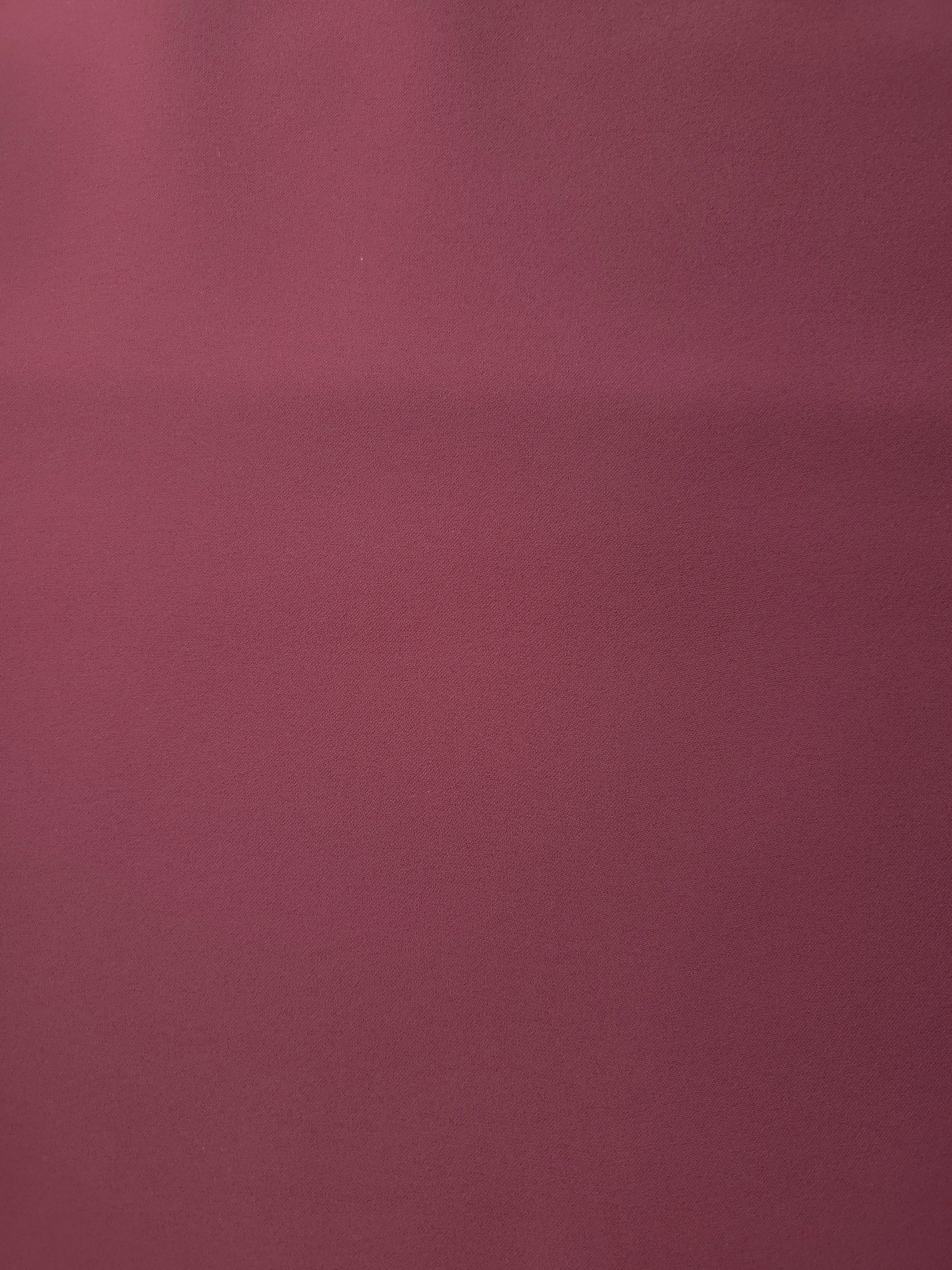 Flat surface of Muted Wine Red Italian crepe, smooth polyester apparel fabric with an elegant silky-feel character