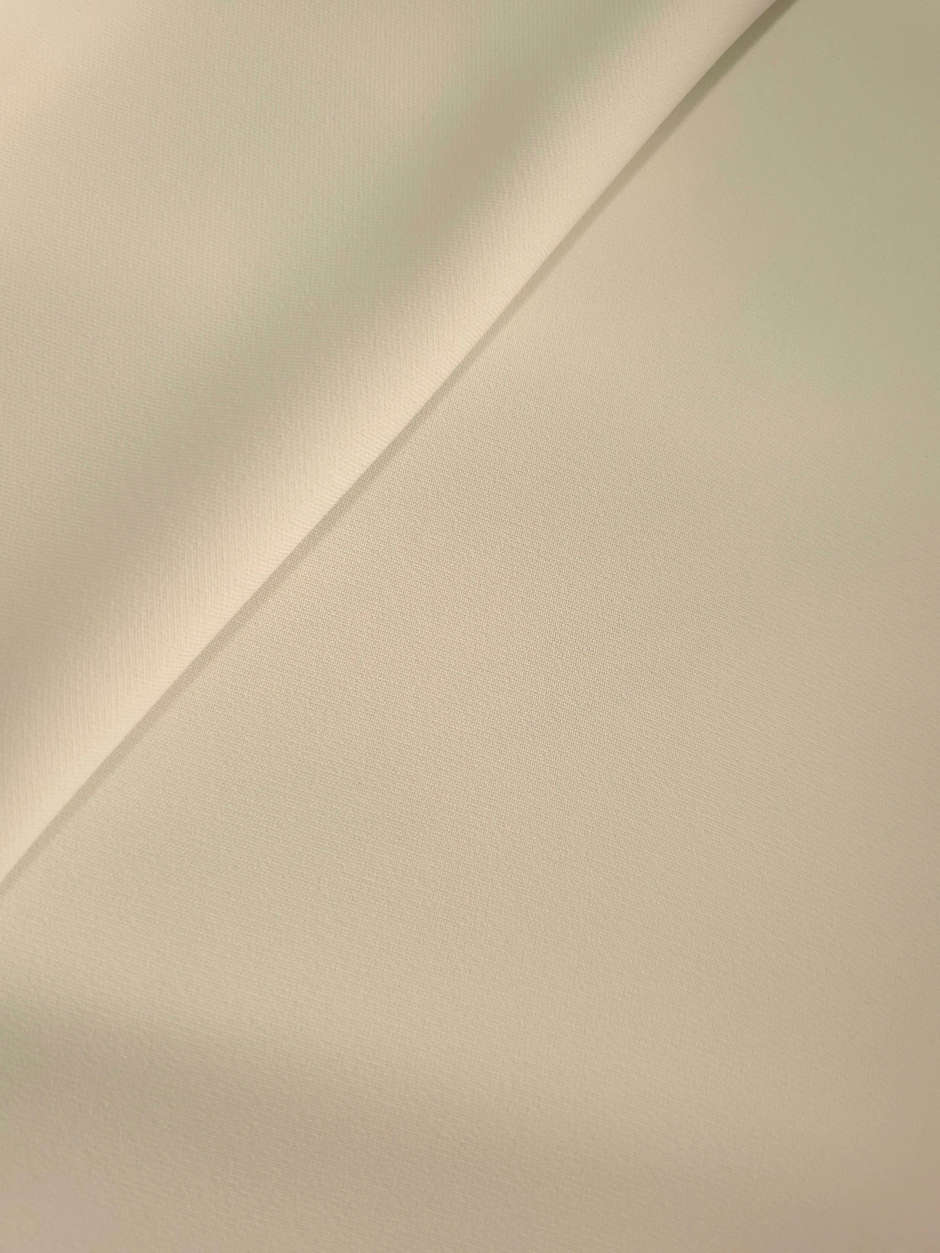 Relaxed fold of Oatmeal Beige polyester crepe showing fluid movement for blouses, dresses and skirts