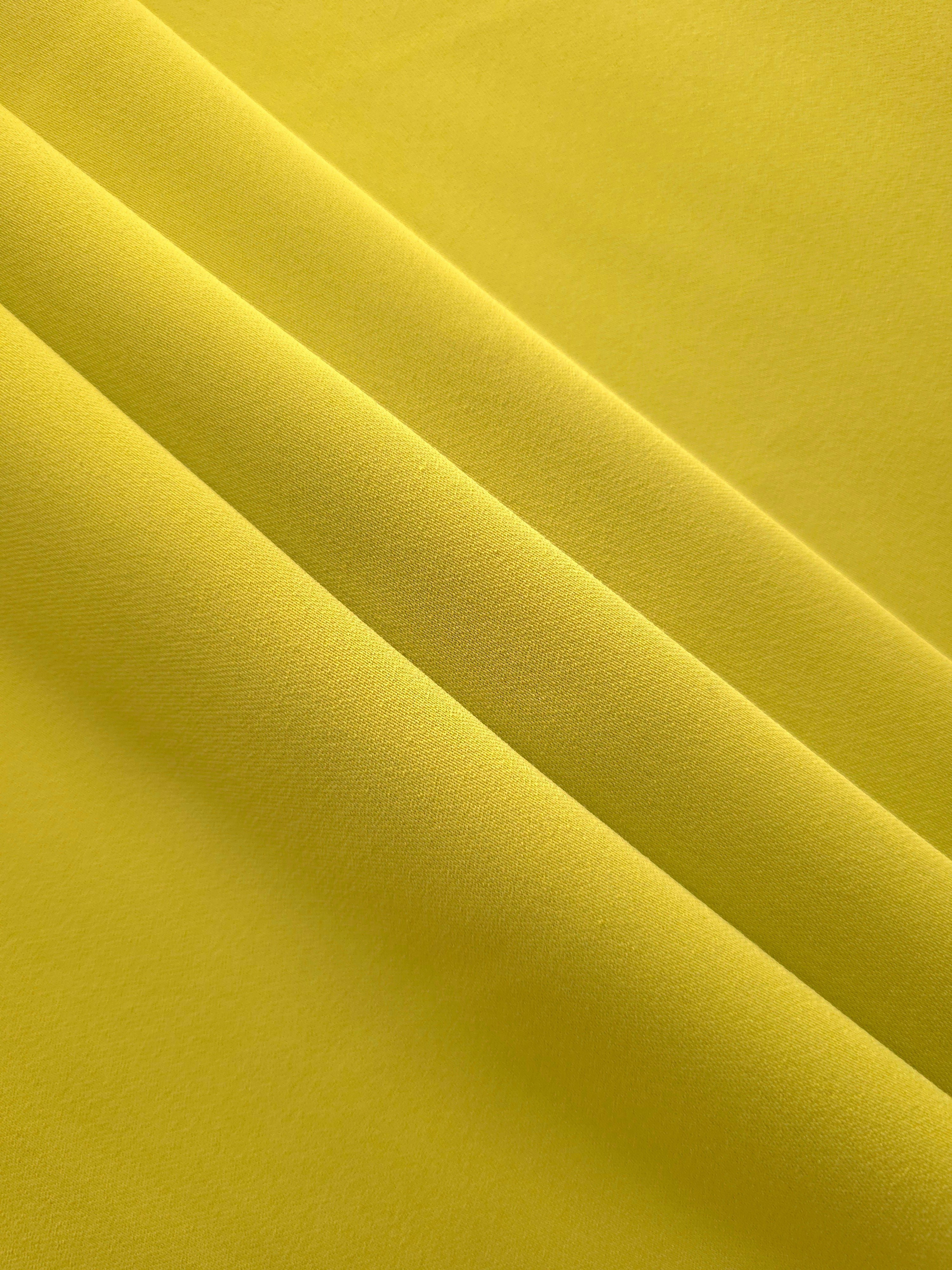 Layered Olive Gold mechanical polyester crepe showing soft structure and gentle stretch for light tailoring