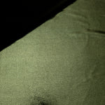 Gently folded Olive Green shimmer spandex fabric showing luminous foil finish for tops, skirts and occasion garments