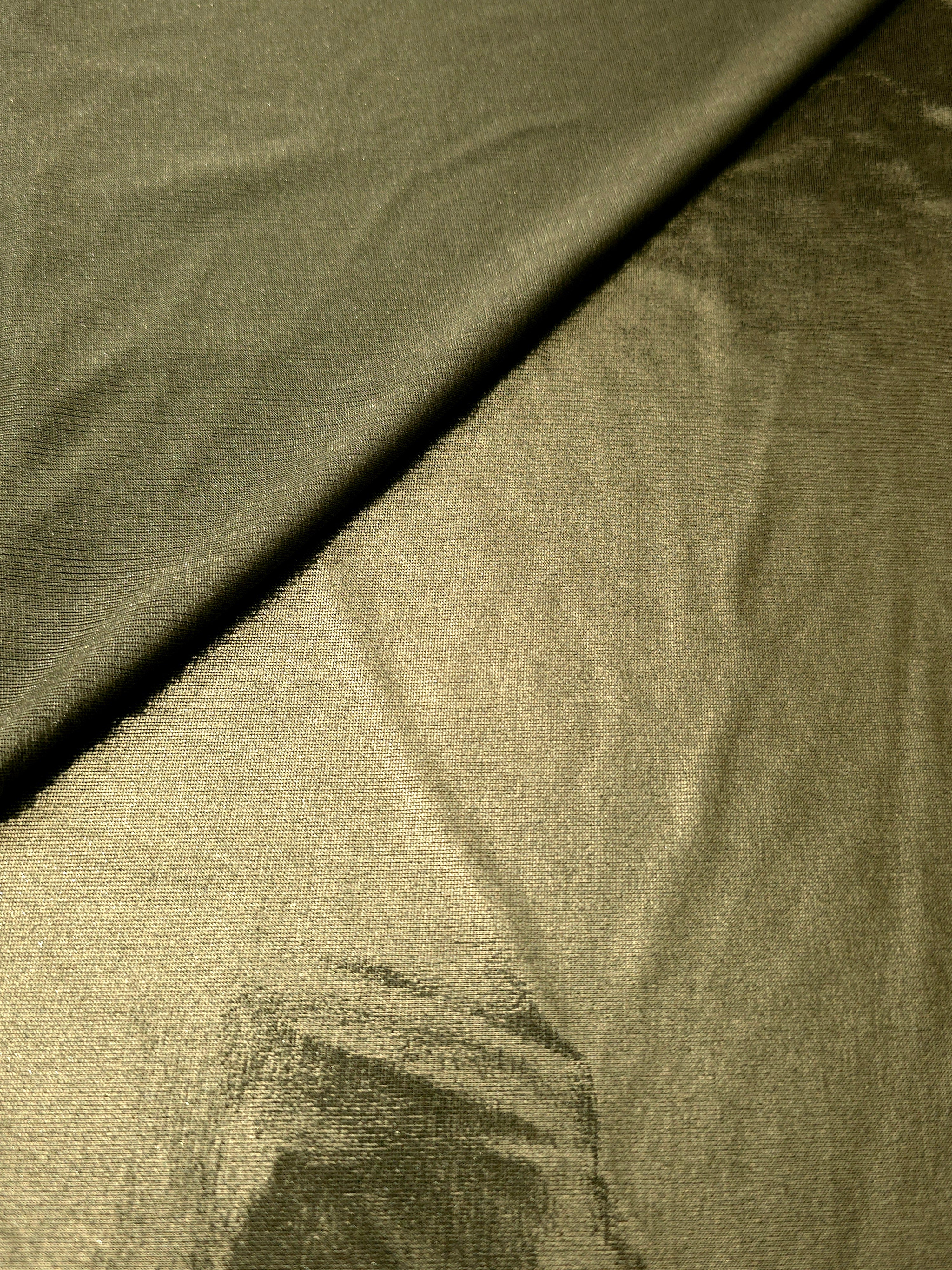 Gently folded Olive Khaki shimmer spandex fabric showing luminous foil finish for tops, skirts and occasion garments