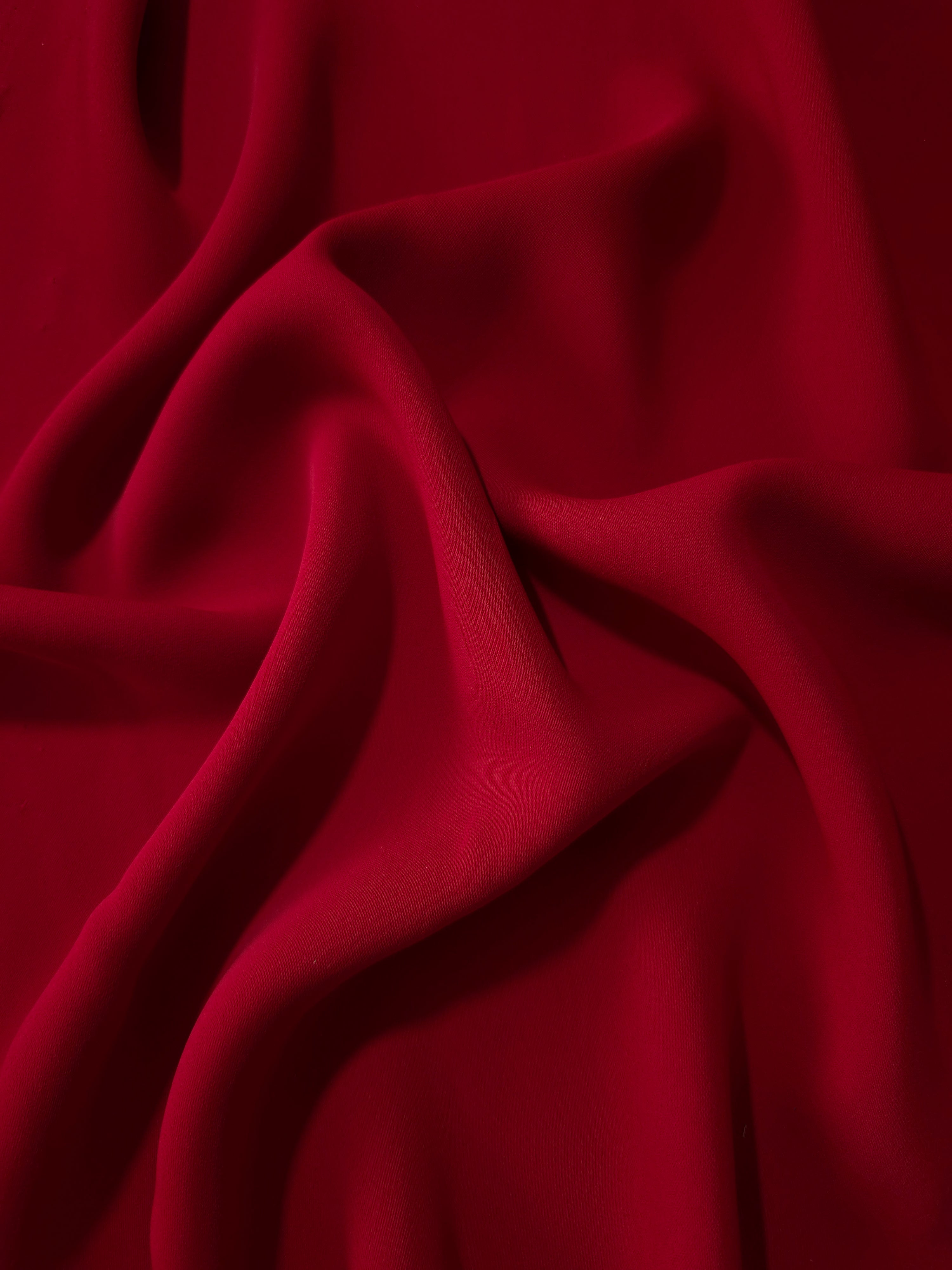 Oxblood Red polyester crepe in long draped folds, showing flowing coverage for abayas and modest fashion