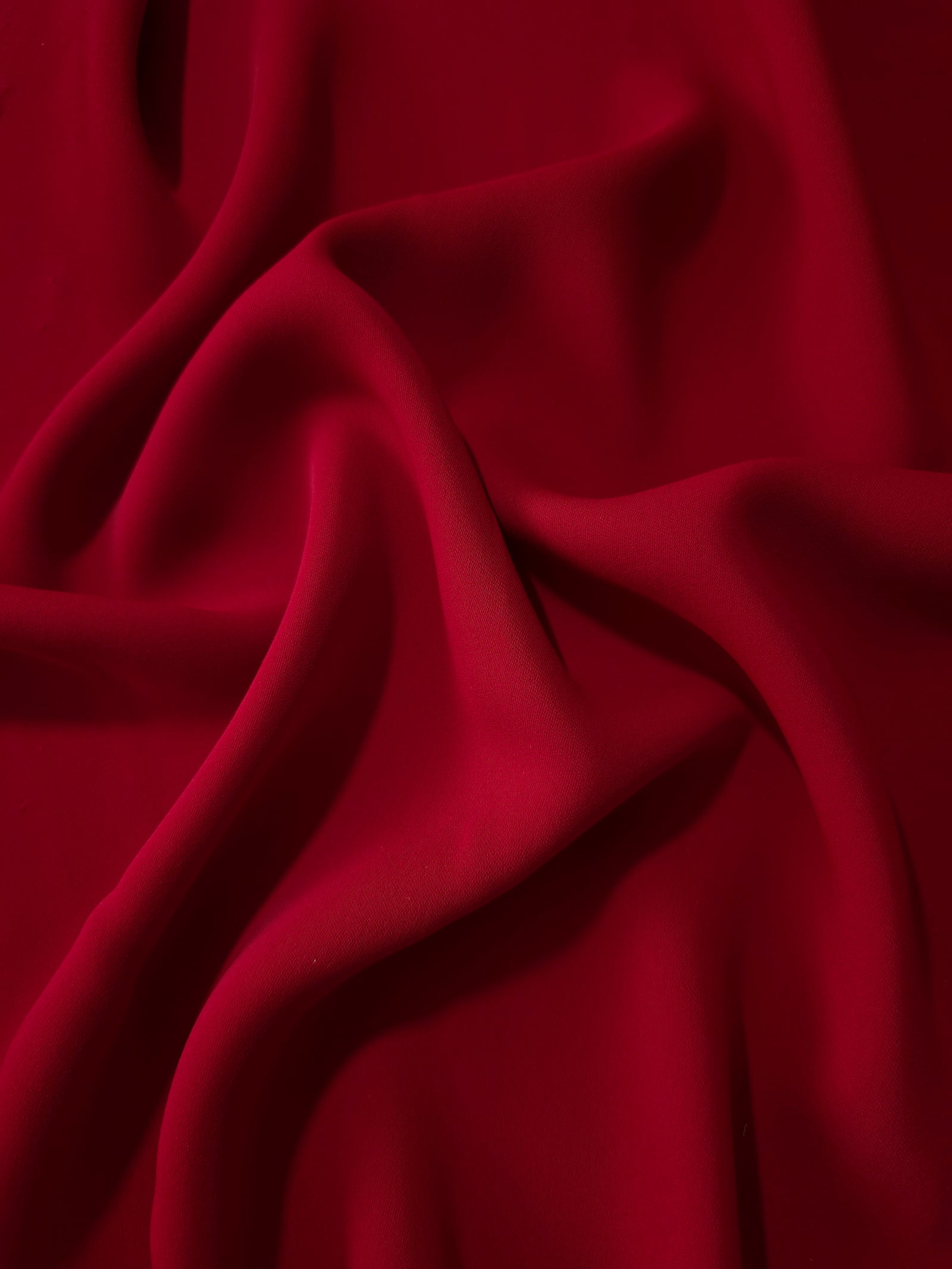 Oxblood Red polyester crepe in long draped folds, showing flowing coverage for abayas and modest fashion