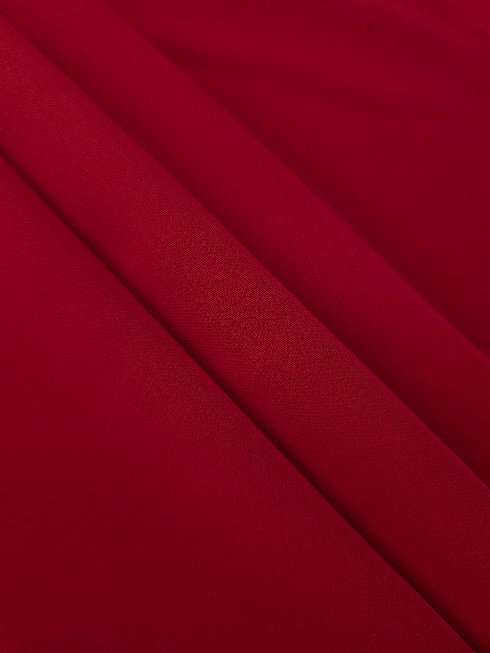 Oxblood Red Korean crepe in layered folds, showing soft structure and slight mechanical stretch for skirts
