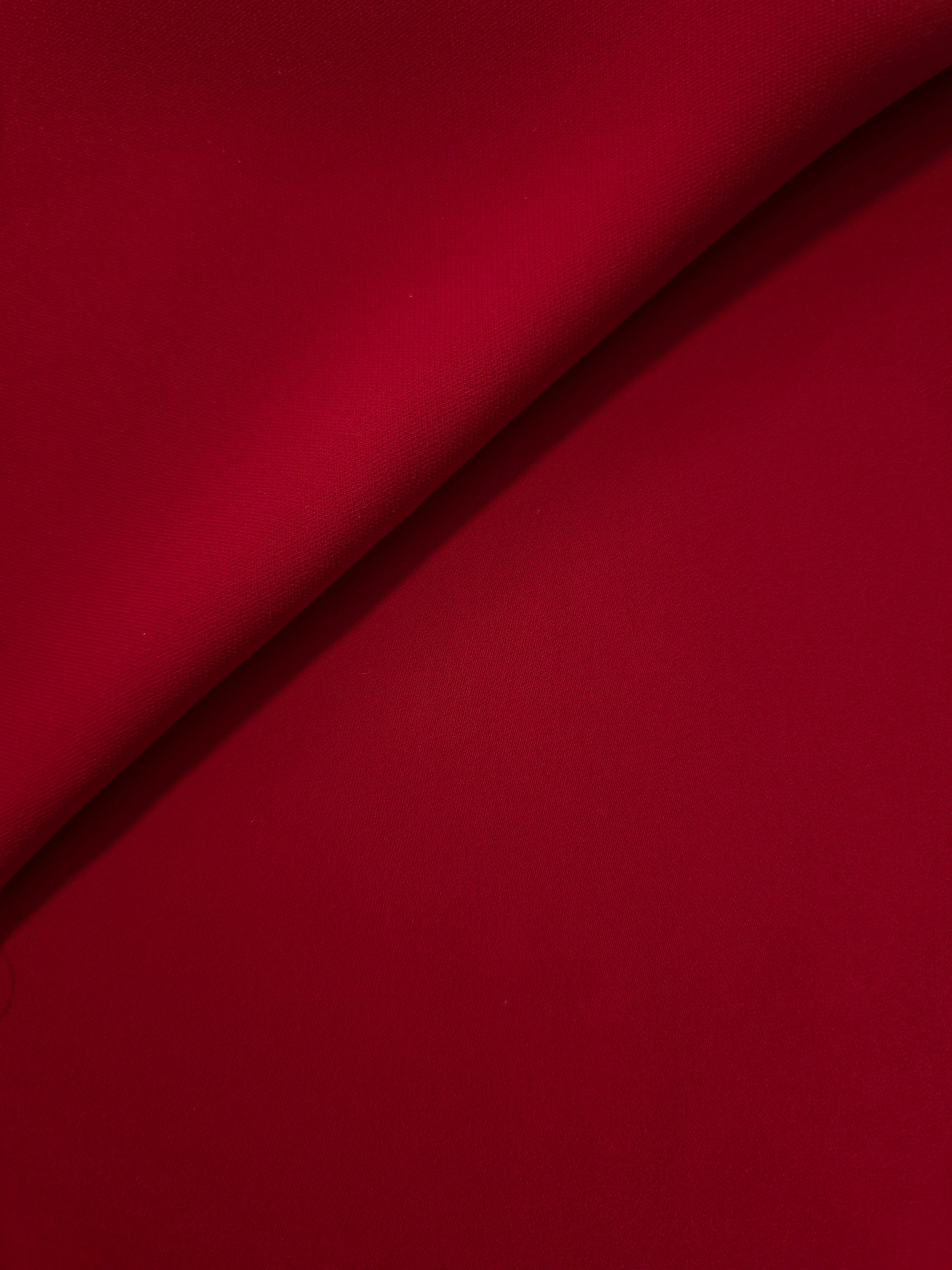 Soft fold of Oxblood Red opaque polyester crepe showing fluid dressmaking drape for dresses and skirts