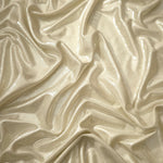 Flowing folds of Pale Butter Cream metallic foiled spandex, showing shimmer and drape for dancewear, party dresses and performance fashion