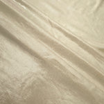 Layered folds of Pale Butter Cream foiled stretch fabric showing shimmer, body and movement for performance outfits and statement garments