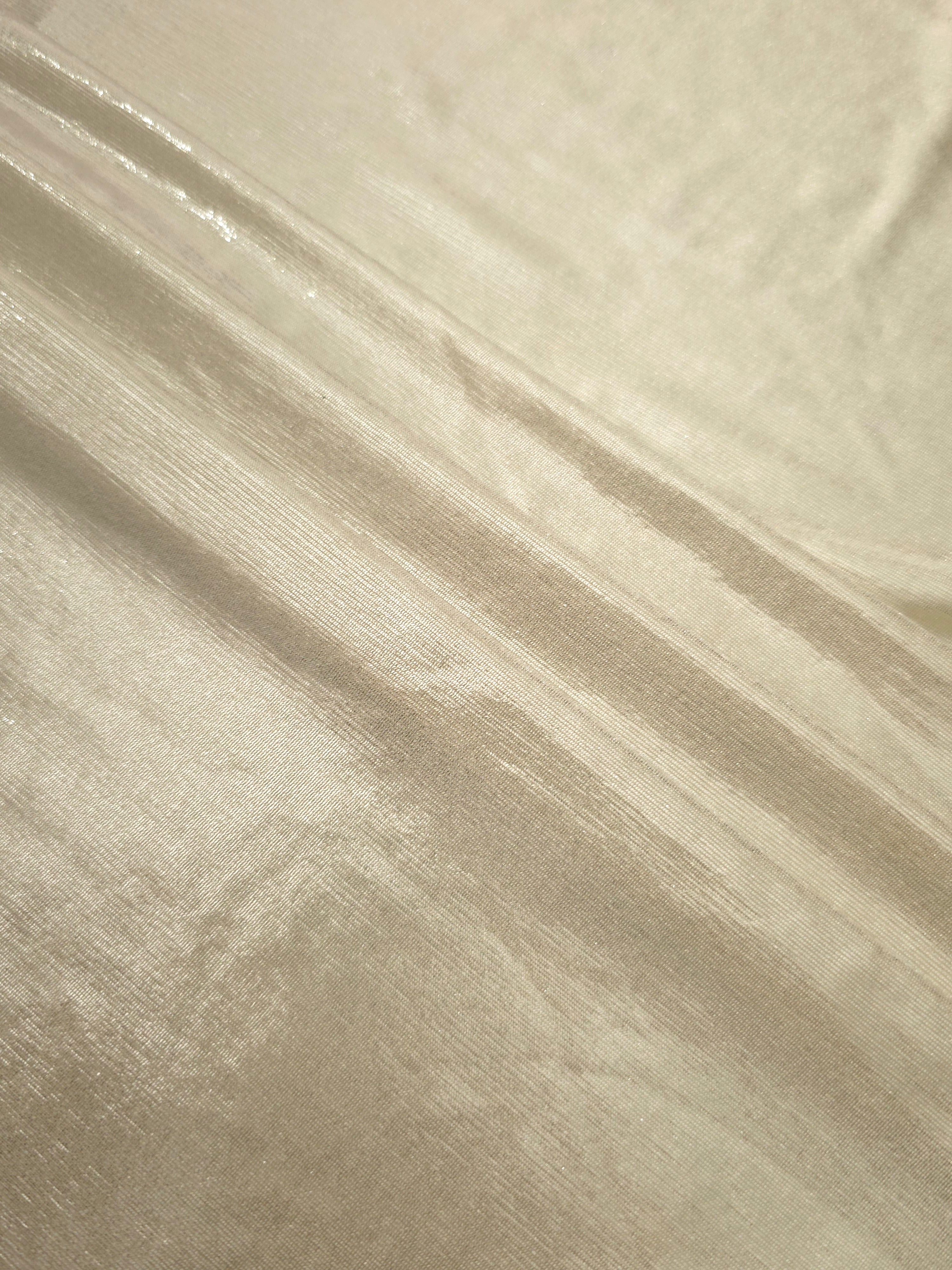 Layered folds of Pale Butter Cream foiled stretch fabric showing shimmer, body and movement for performance outfits and statement garments