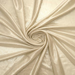 Pale Butter Cream metallic stretch fabric in a flowing swirl, emphasizing foil shimmer and drape for partywear and statement fashion