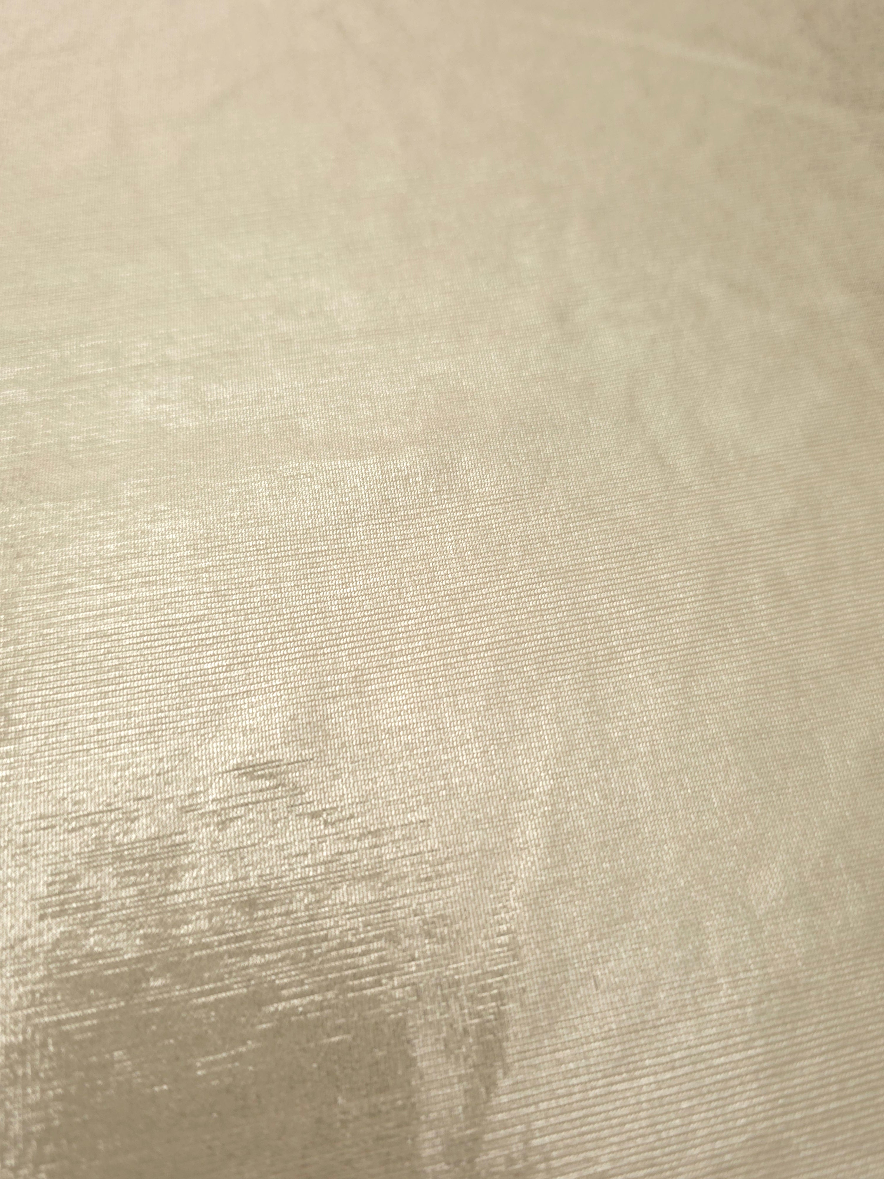 Detailed close-up of Pale Butter Cream foiled spandex fabric showing its luminous metallic surface and fine reflective texture