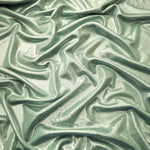 Pale Sage Green metallic stretch fabric arranged in elegant folds, showing reflective movement for occasionwear, costumes and fashion design