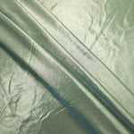Layered Pale Sage Green metallic stretch fabric with reflective foil finish, showing flexible body for dancewear and occasion fashion