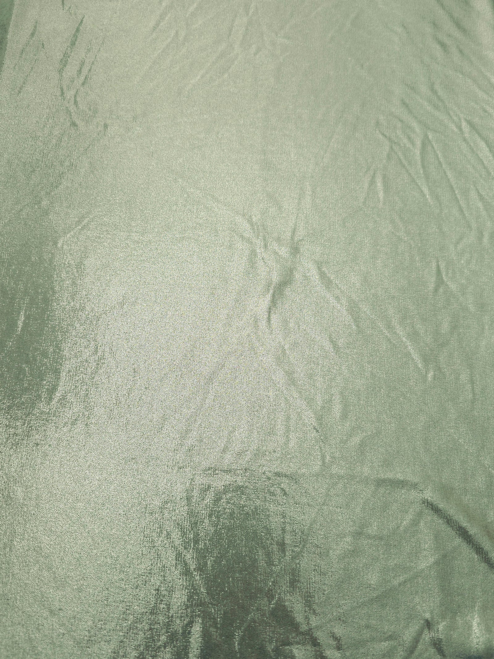 Pale Sage Green shimmer metallic foiled spandex shown flat, displaying reflective finish for dance costumes, skirts and event apparel