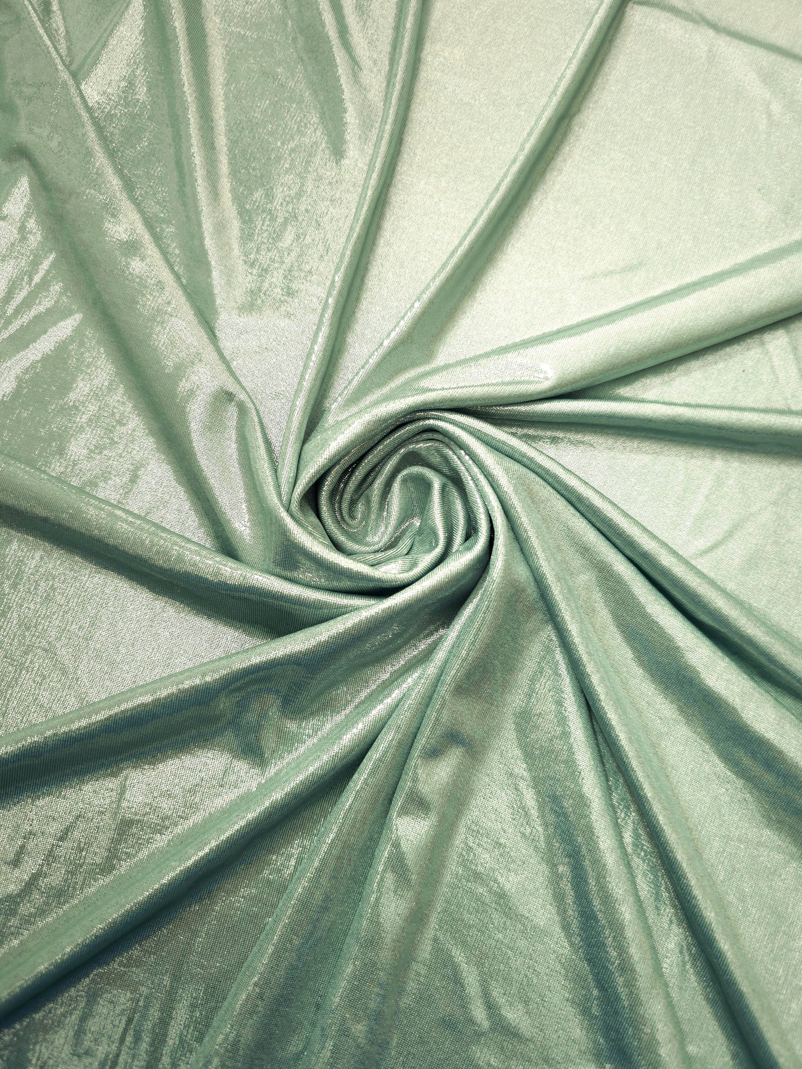Pale Sage Green foiled spandex styled in a swirl, revealing metallic shine and flexible drape for dance costumes and occasion looks