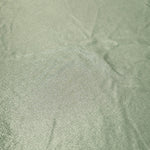 Close-up Pale Sage Green shimmer metallic spandex showing reflective foil detail and the fabric surface for statement garments
