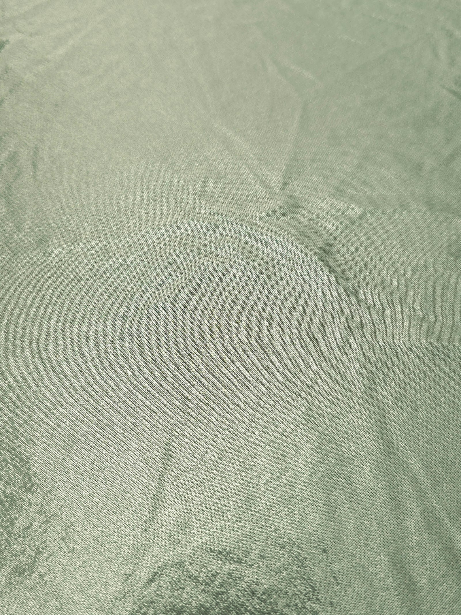 Close-up Pale Sage Green shimmer metallic spandex showing reflective foil detail and the fabric surface for statement garments