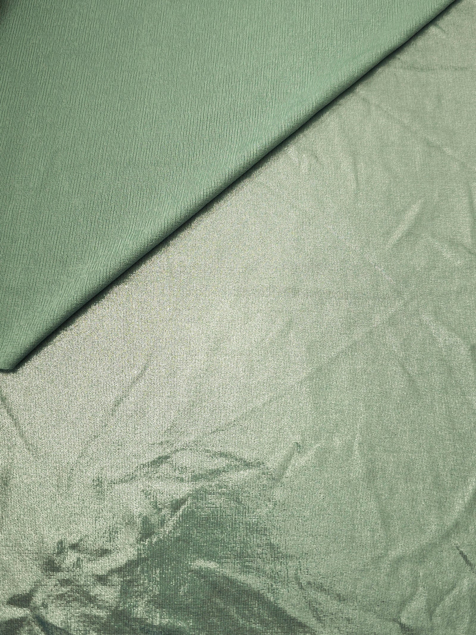 Pale Sage Green metallic stretch fabric in a soft fold, revealing reflective drape for dancewear, dresses and statement apparel