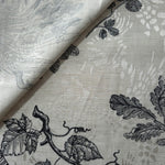 Black palm vine jacquard fabric close-up detail with woven leaf pattern and linen-look texture.