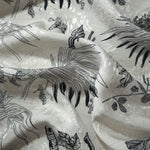 Black palm vine linen-look jacquard fabric draped to show soft structure and tonal botanical design.