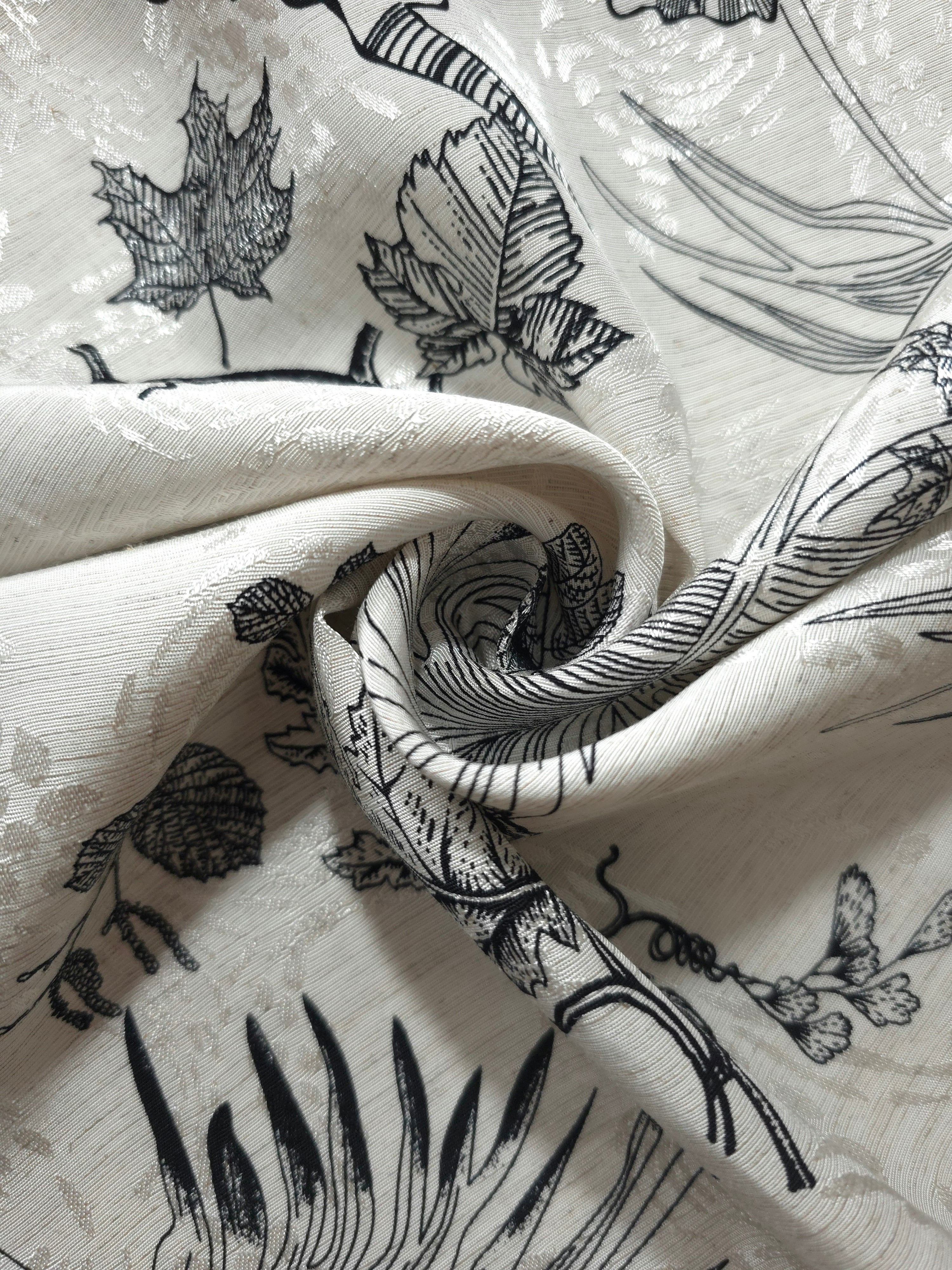 Black palm vine linen-look jacquard fabric folded view showing matte texture and woven pattern.