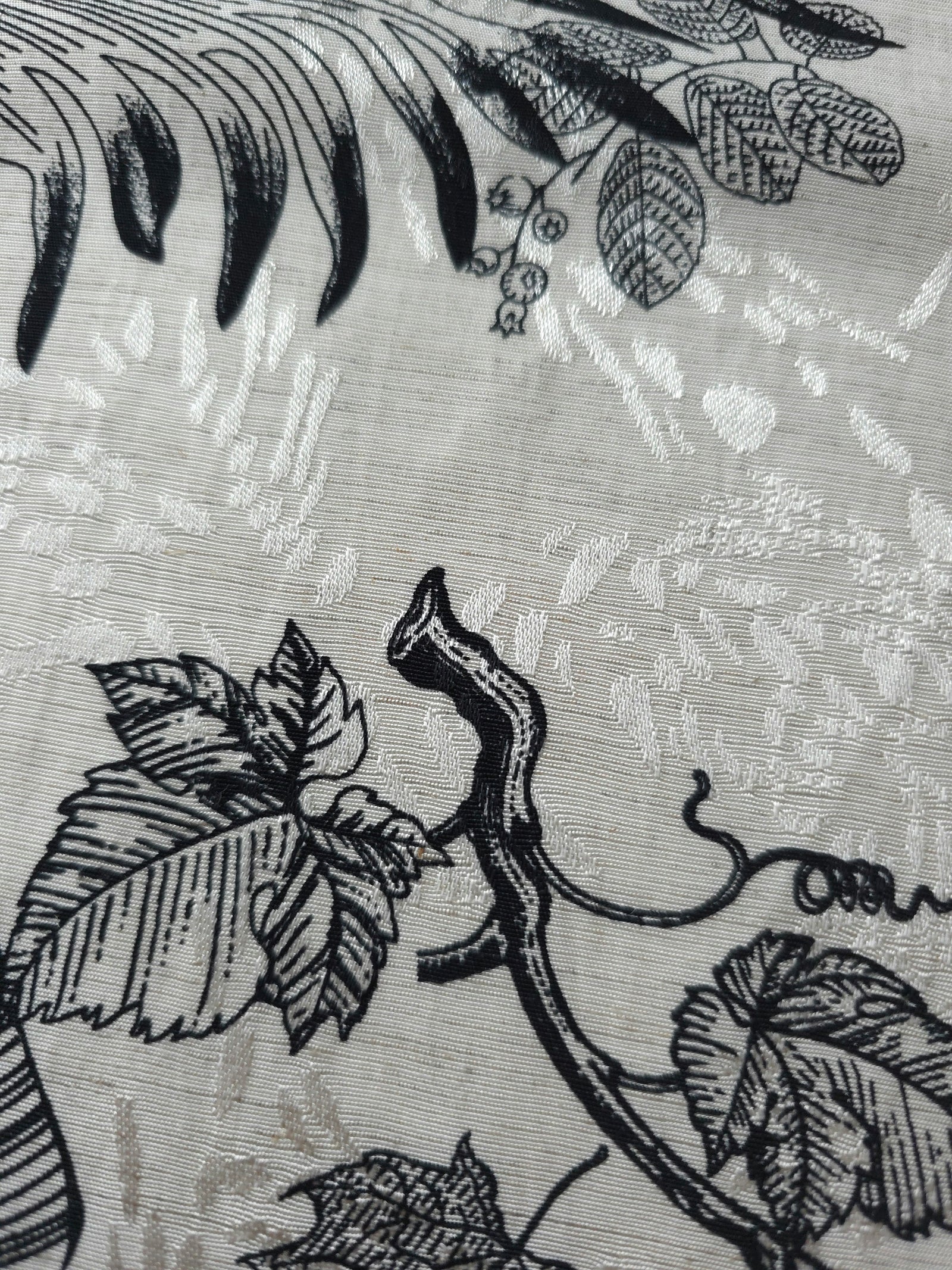 Black palm vine linen-look jacquard fabric pattern overview with tonal leaf and vine motif.