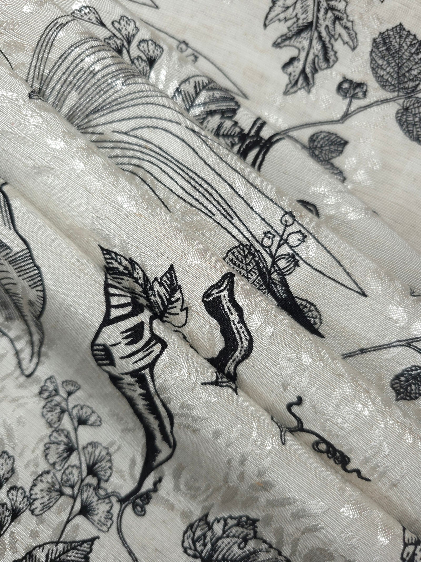 Reverse side of black palm vine jacquard fabric showing woven structure and linen-like surface.