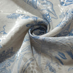 Blue palm vine linen-look jacquard fabric draped to show soft structure and woven botanical movement.