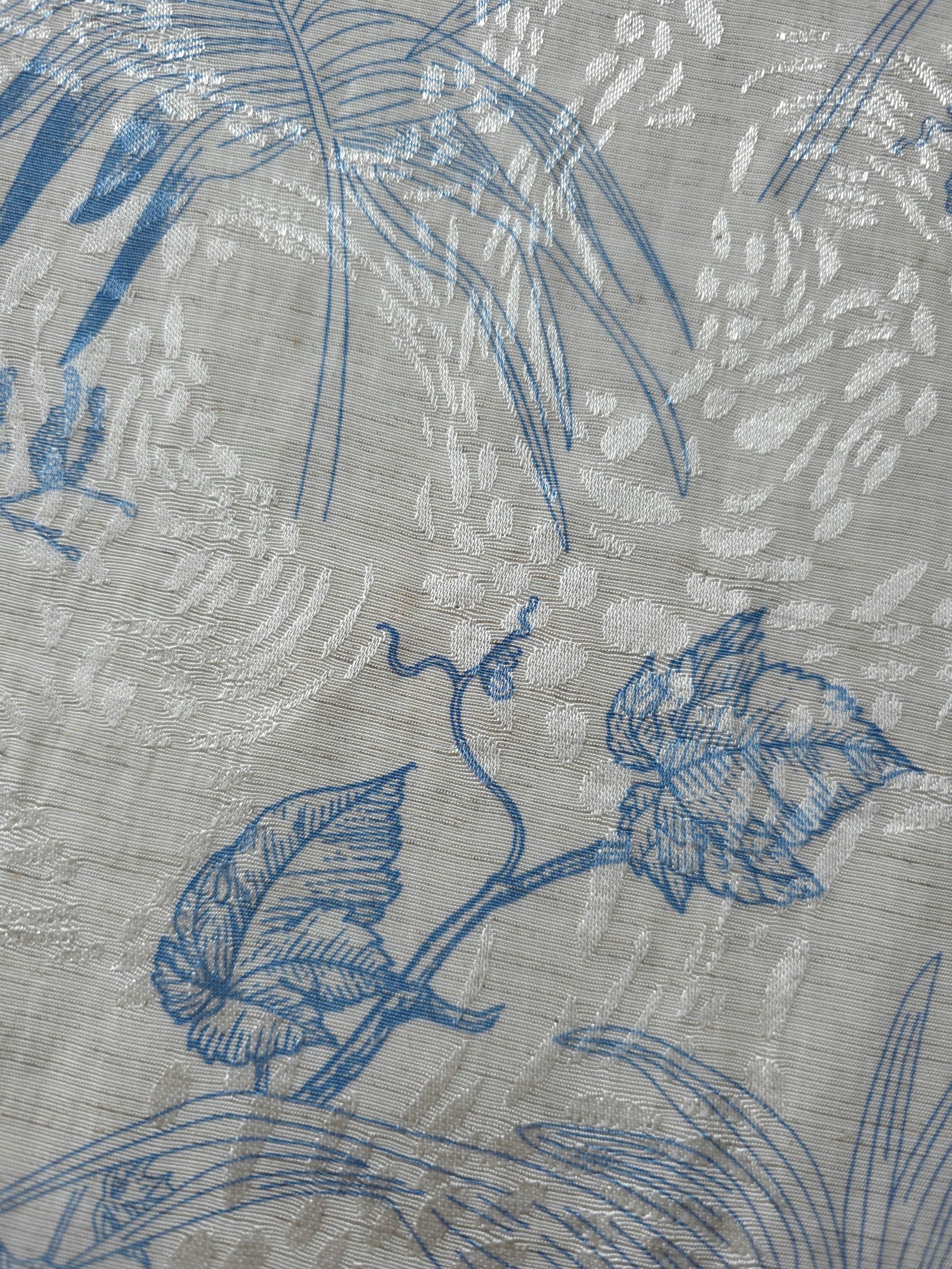 Blue palm vine linen-look jacquard fabric pattern overview with tonal leaf and vine design.