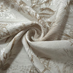 Brown palm vine linen-look jacquard fabric folded view showing apparel drape and woven leaf design.