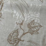 Texture view of brown palm vine linen-look jacquard fabric with woven leaf and vine pattern.