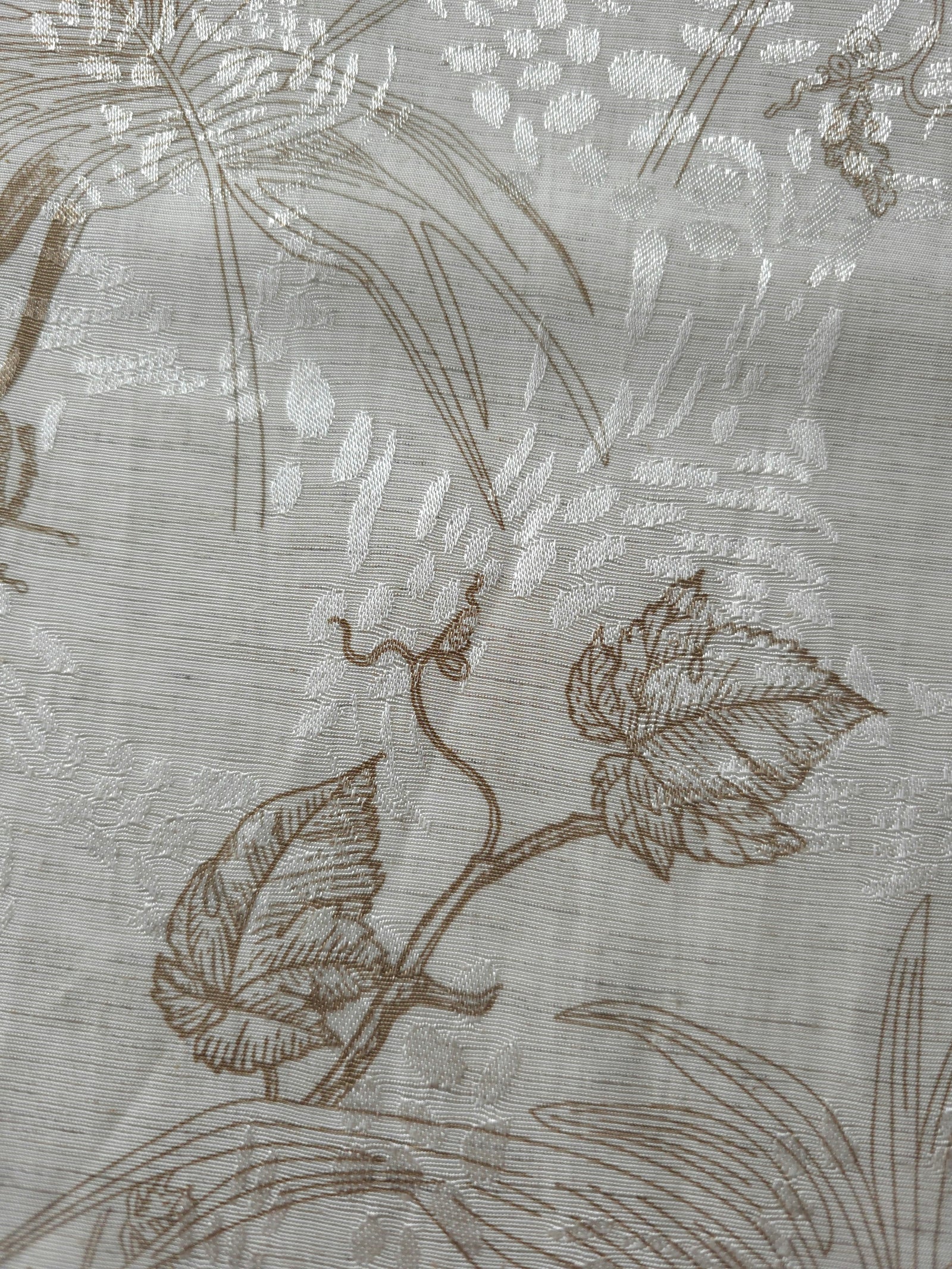 Texture view of brown palm vine linen-look jacquard fabric with woven leaf and vine pattern.