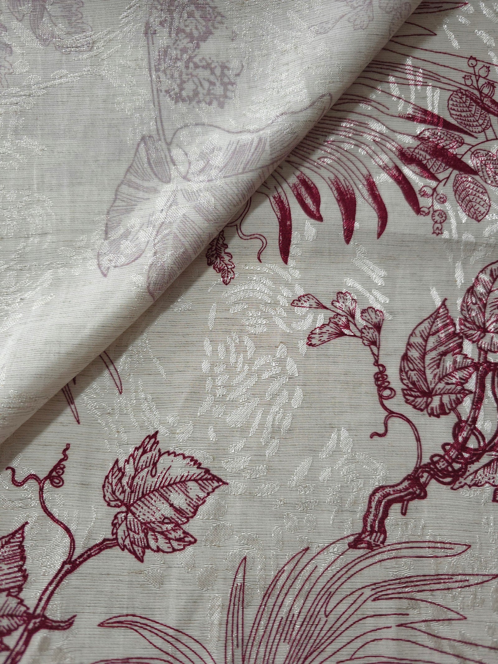 Deep red palm vine jacquard fabric close-up with woven leaf motif and linen-look texture.