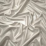 Flowing folds of Pearl Ivory metallic foiled spandex, showing shimmer and drape for dancewear, party dresses and performance fashion