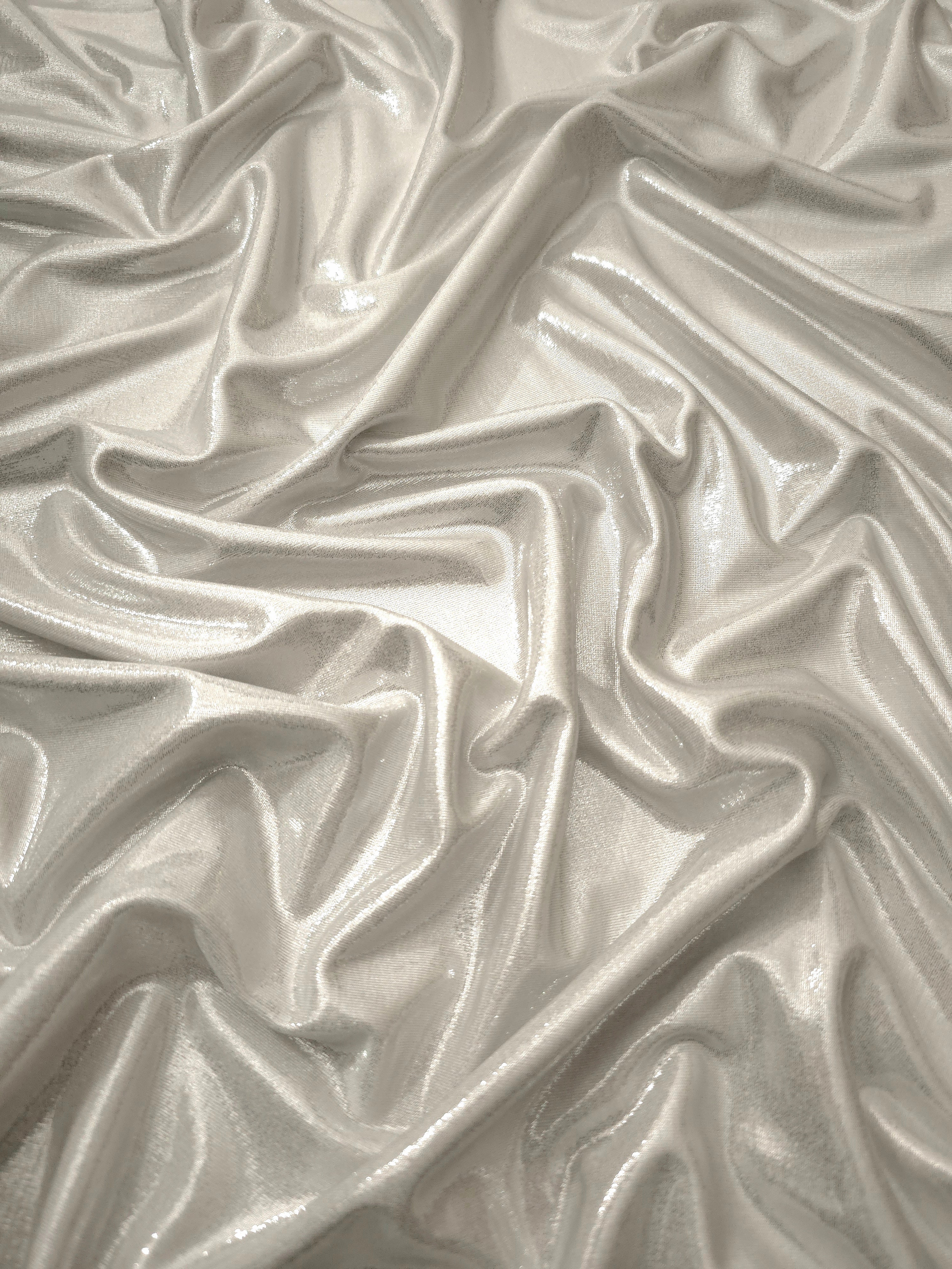 Flowing folds of Pearl Ivory metallic foiled spandex, showing shimmer and drape for dancewear, party dresses and performance fashion