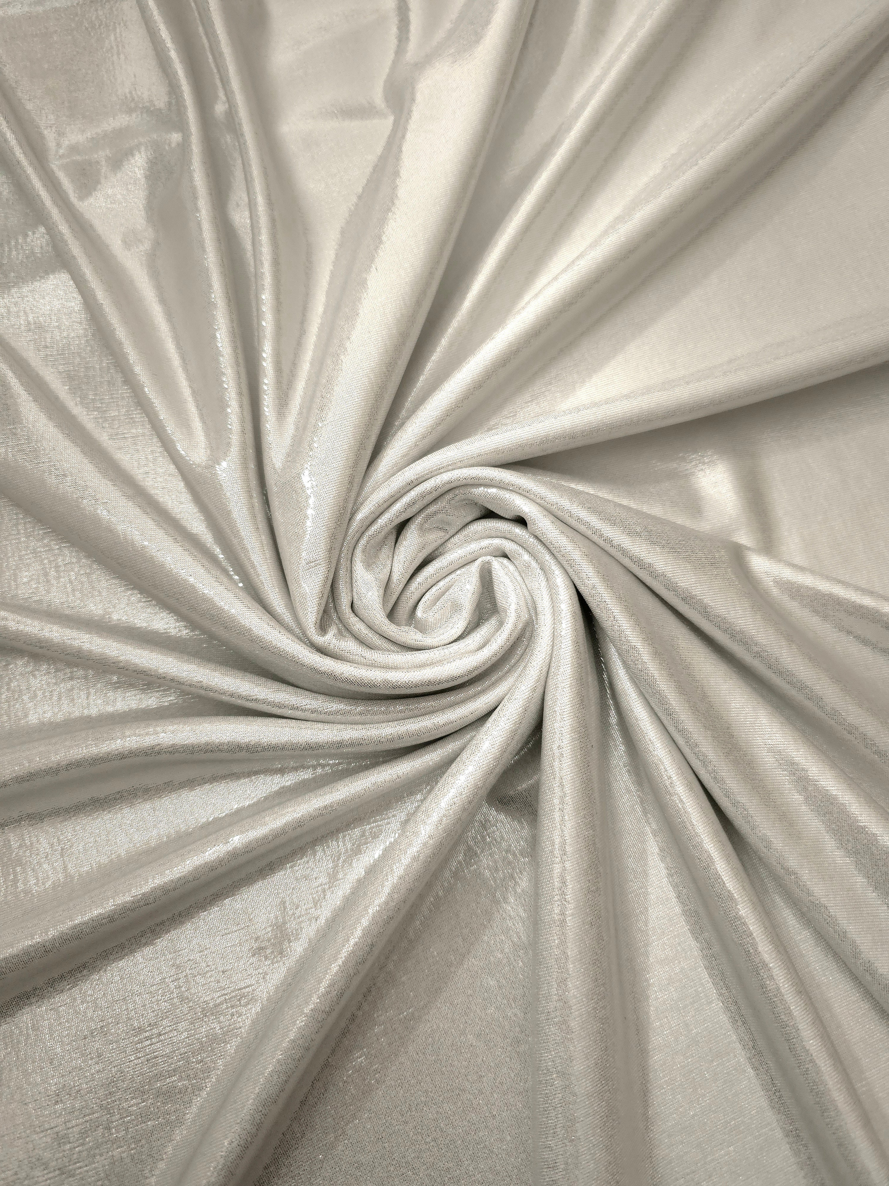 Pearl Ivory metallic stretch fabric in a flowing swirl, emphasizing foil shimmer and drape for partywear and statement fashion