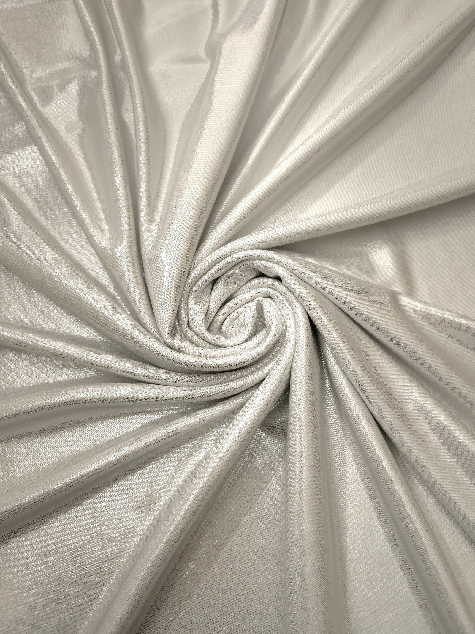 Pearl Ivory metallic stretch fabric in a flowing swirl, emphasizing foil shimmer and drape for partywear and statement fashion
