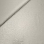 Pearl Ivory foiled stretch fabric in a gentle fold, showing metallic shimmer and flexibility for partywear and performance fashion