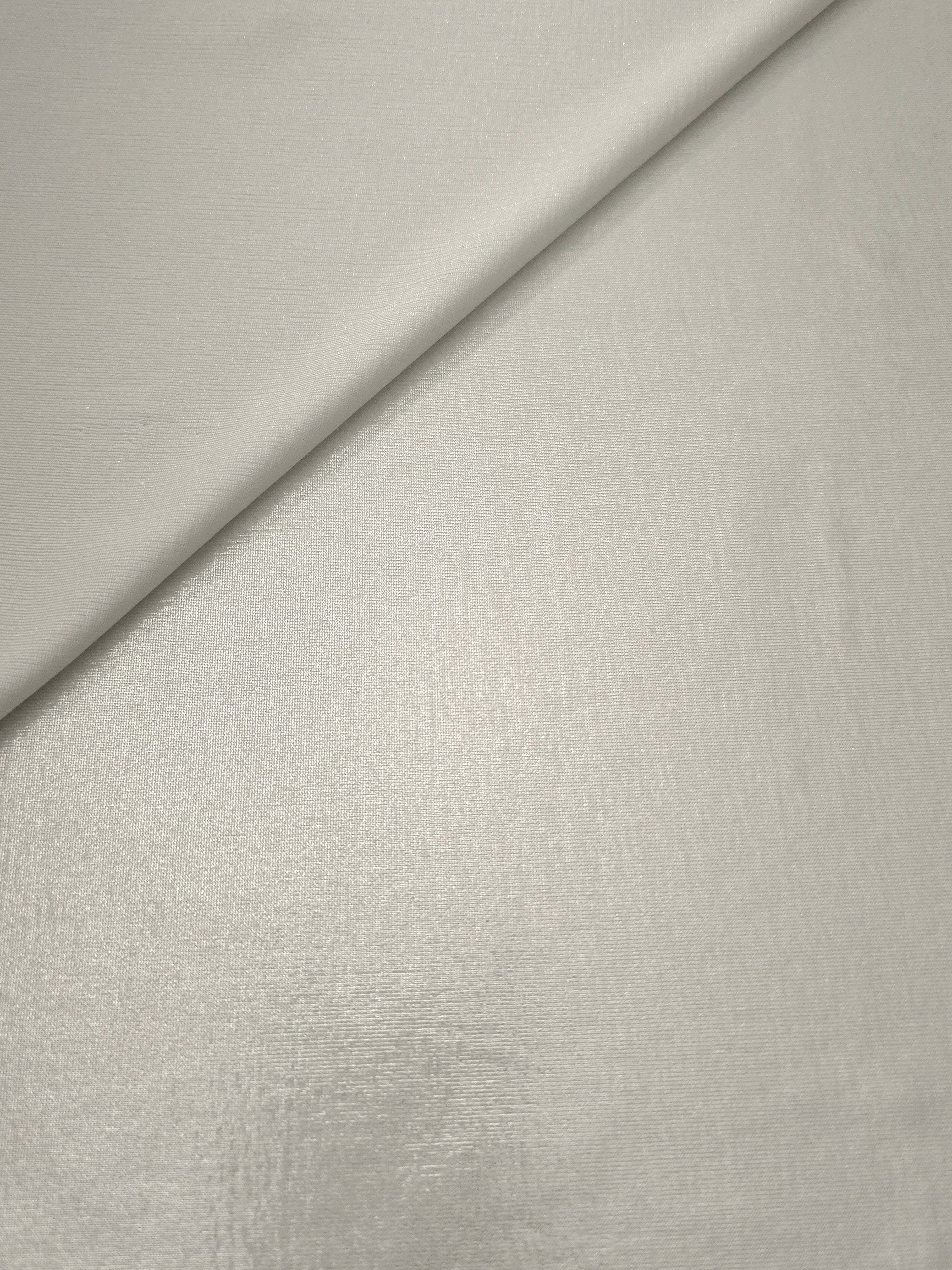 Pearl Ivory foiled stretch fabric in a gentle fold, showing metallic shimmer and flexibility for partywear and performance fashion