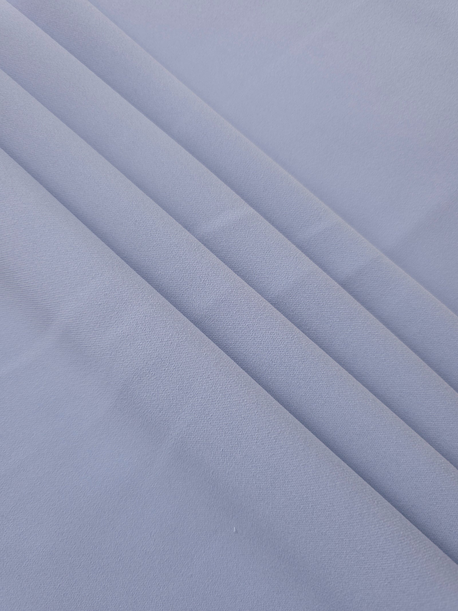 Layered Periwinkle Blue Korean polyester crepe showing gentle mechanical stretch and soft structure for dressmaking
