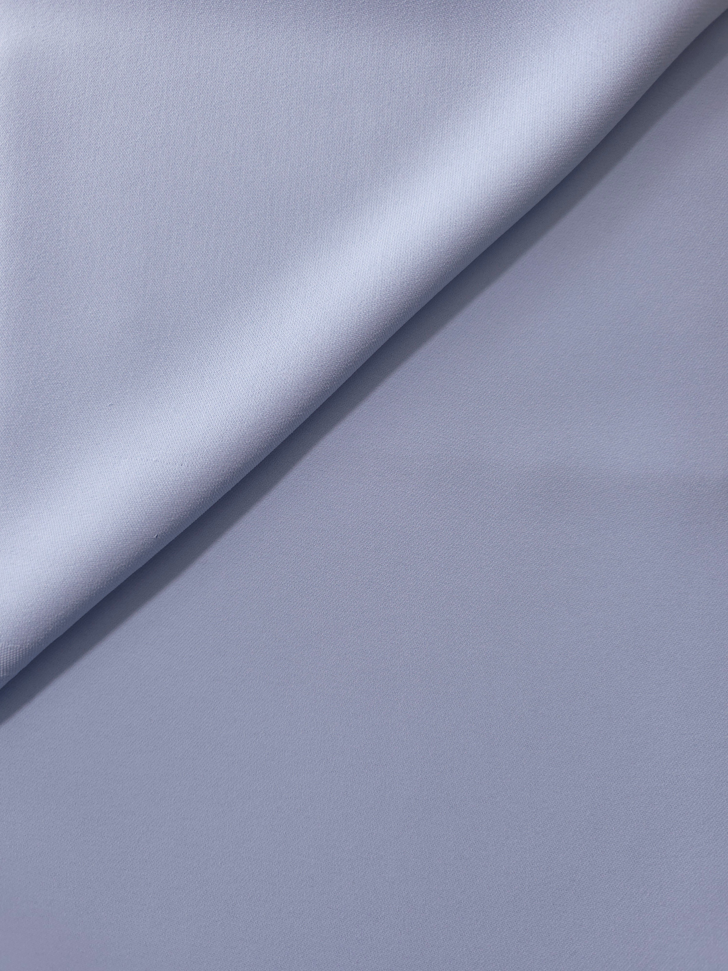 Periwinkle Blue opaque Korean polyester crepe in a soft fold, showing flowing drape for garment making