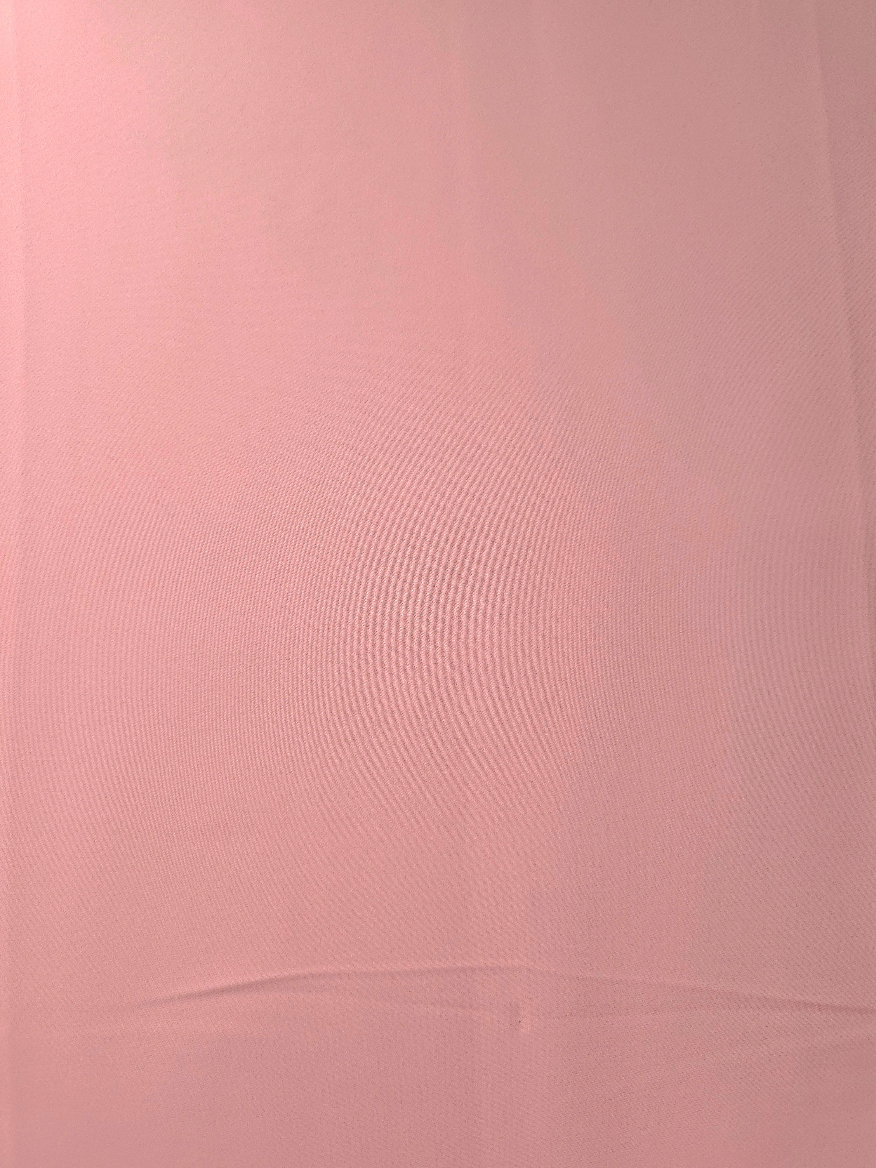 Flat surface of Powder Rose Pink Italian crepe, smooth polyester apparel fabric with an elegant silky-feel character