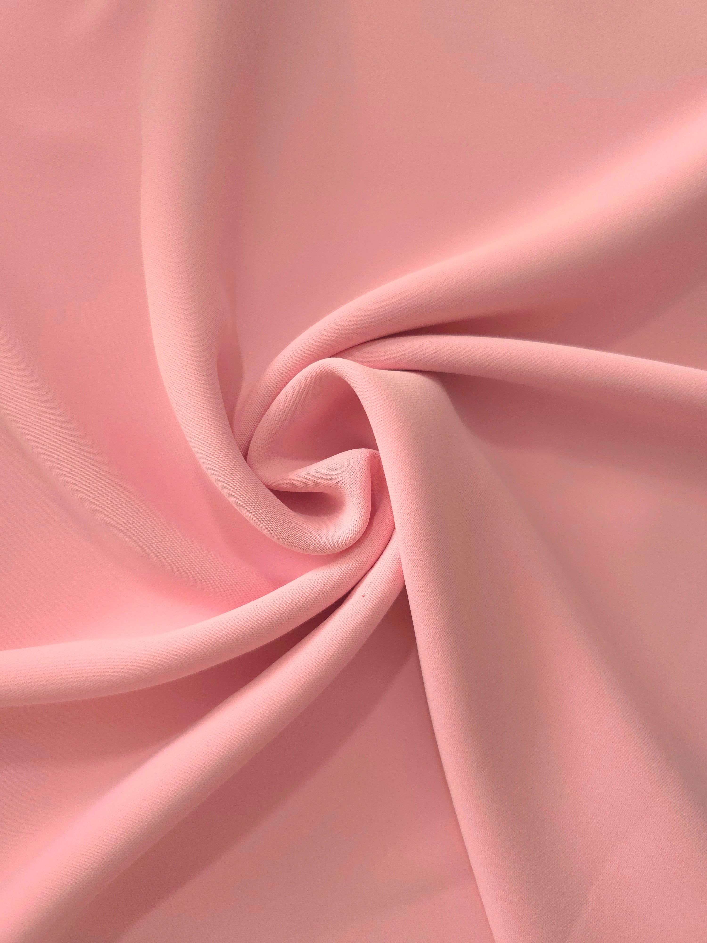 Circular drape of Powder Rose Pink polyester crepe showing flowing movement for occasion dresses and modest fashion