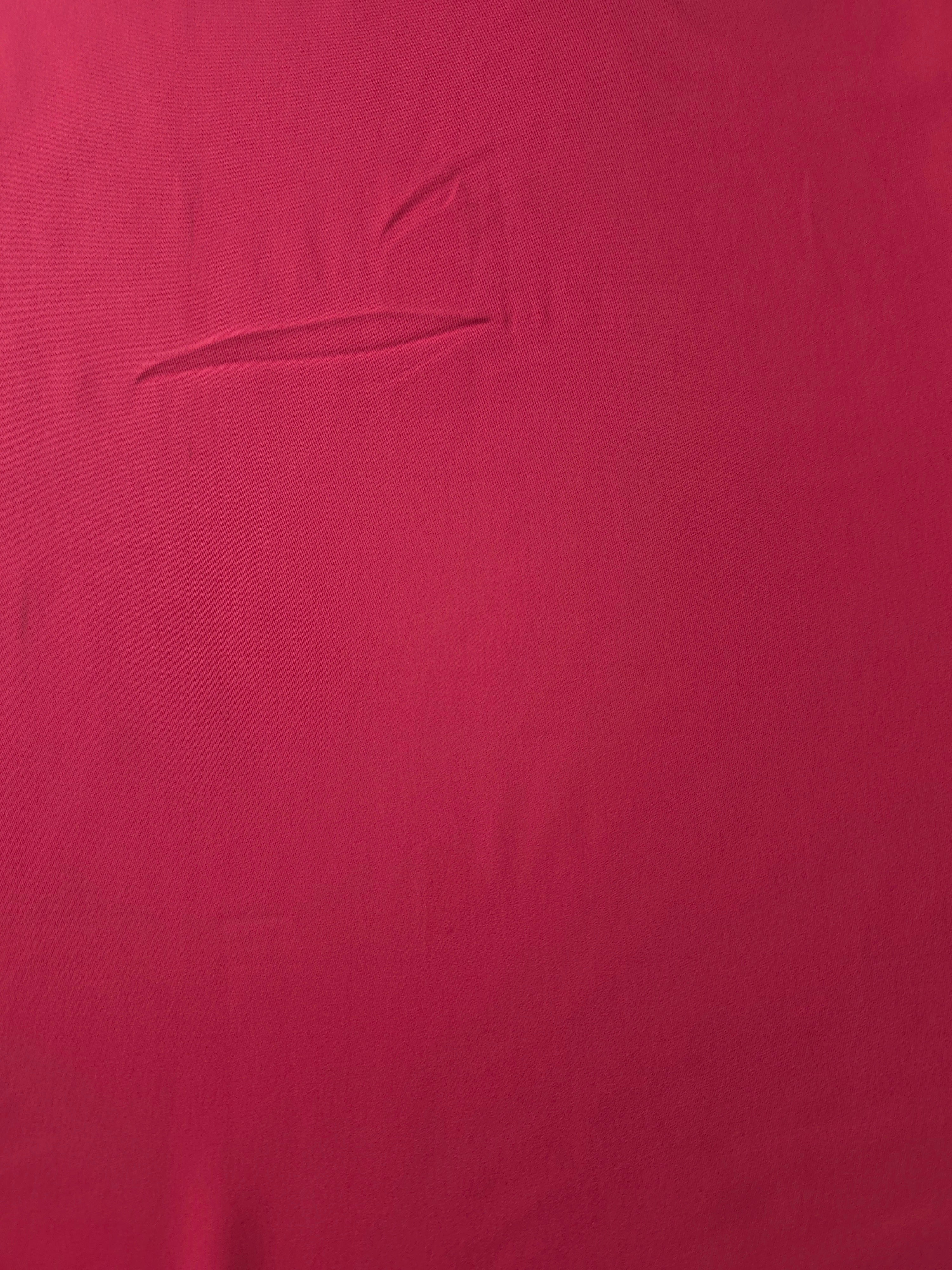Surface view of Raspberry Red 205 GSM polyester crepe, opaque Korean dress fabric with a smooth woven finish