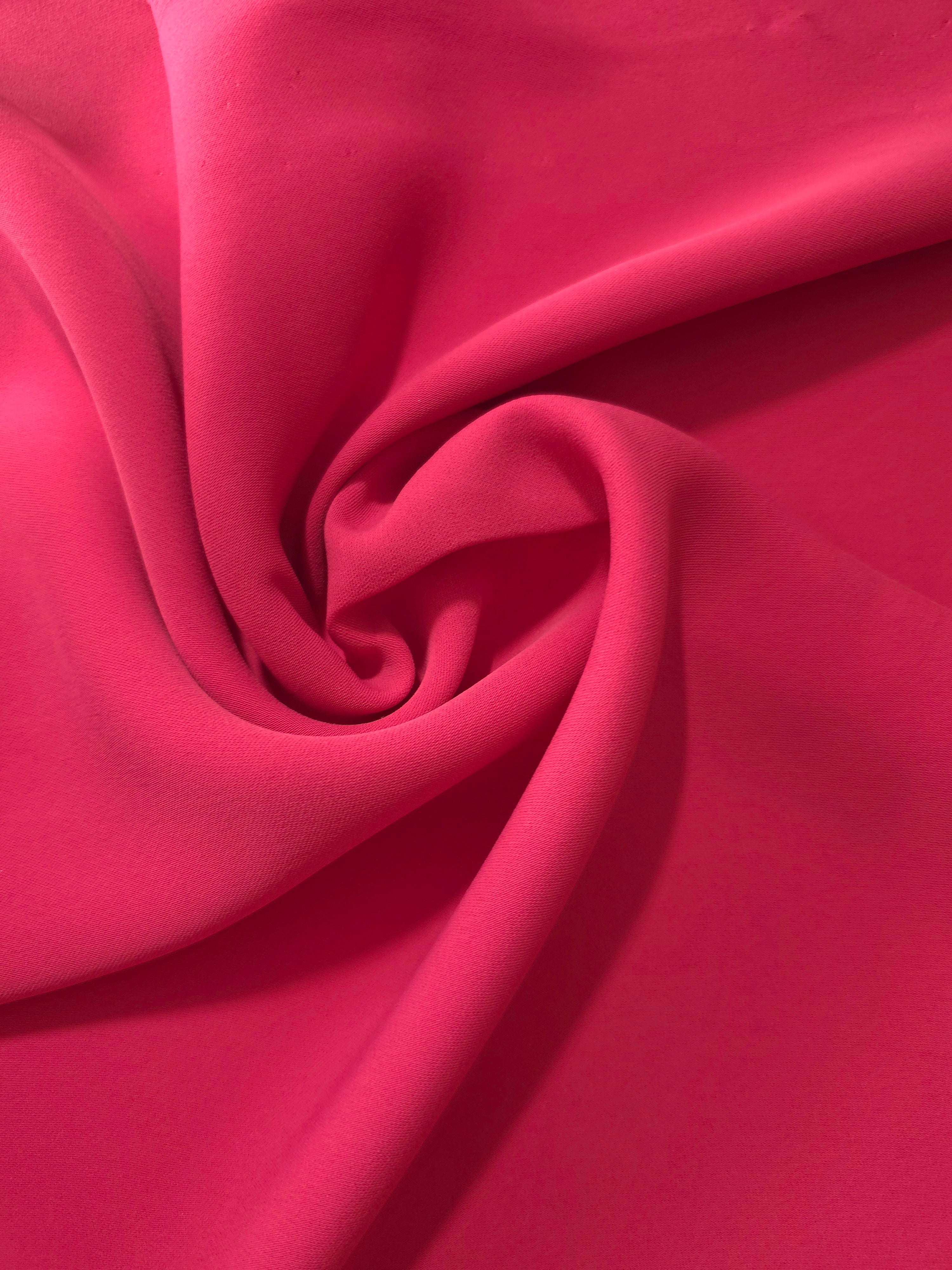 Flowing swirl of Raspberry Red Korean polyester crepe showing soft drape for blouses, dresses and abayas