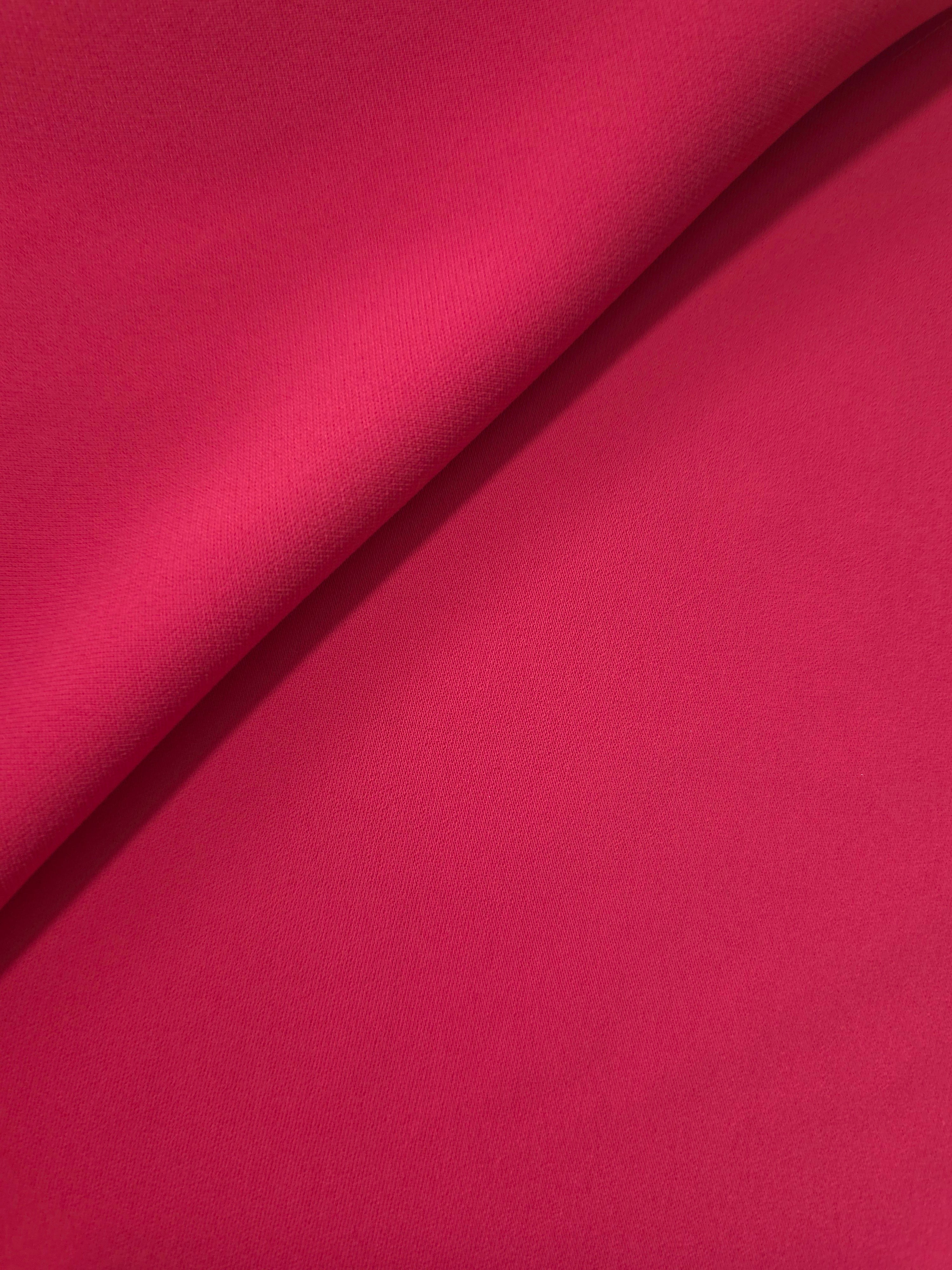Loose fold of Raspberry Red polyester crepe showing smooth fluid drape for dresses, skirts and soft tailoring
